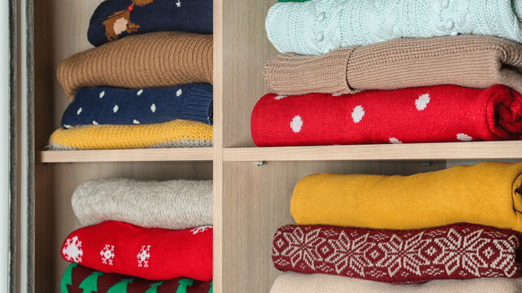 Folded sweaters stacked on open closet shelves, featuring small walk-in closet ideas for seasonal clothing storage.
